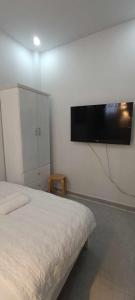 a bedroom with a bed and a flat screen tv on the wall at Vy Khanh Guesthouse in Ho Chi Minh City