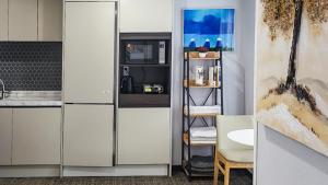 uma cozinha com armários brancos e um frigorífico em Griffinbay Hotel em Busan