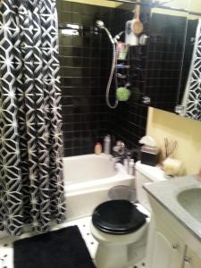 uma casa de banho com um WC e uma cortina de chuveiro preta. em Centrally located; Walk anywhere! em São Francisco