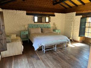 ein Schlafzimmer mit einem großen Bett und zwei Tischen in der Unterkunft Casona Ananda in Firavitoba