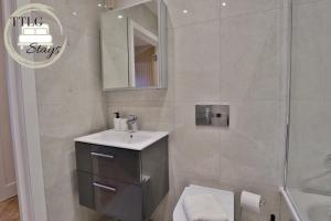 uma casa de banho com um lavatório e um chuveiro em Newly-Built Urban Retreat by TTLG Stays em Rickmansworth