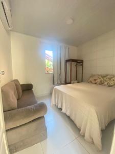 1 dormitorio con 1 cama y 1 sofá en Residencial Morro de São Paulo Casa Amarela, en Morro de São Paulo