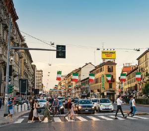 ミラノにあるHotel Aurelia Milano Centraleの賑やかな街路を横断する人々