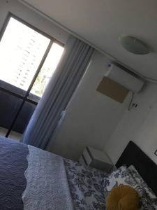 福塔萊薩的住宿－Apartamento MOBILIADO 200m do mar com vista mar, garagem, ar condicionado，一间卧室设有一张床和一个大窗户