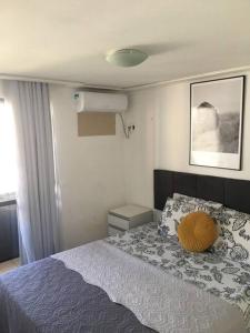 a bedroom with a bed with a yellow pillow on it at Apartamento MOBILIADO 200m do mar com vista mar, garagem, ar condicionado in Fortaleza