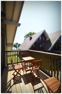 una terrazza in legno con tavolo e sedie. di Smėlynas Neringa Apartments a Neringa