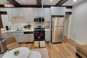 eine Küche mit weißen Schränken und einem Kühlschrank aus Edelstahl in der Unterkunft Elegant Luxury 2BR Apt Near DTLA in Los Angeles