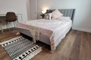 a bedroom with a bed with a quilt and a rug at Elegant Luxury 2BR Apt Near DTLA in Los Angeles