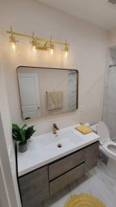 uma casa de banho com um lavatório, um espelho e um WC. em Elegant Luxury 2BR Apt Near DTLA em Los Angeles