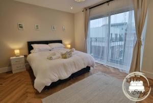 a bedroom with a large bed and a large window at Modern City Escape by TTLG Stays in Rickmansworth