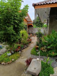 un jardín con un banco de piedra frente a una casa en ต้นโพธิ์โฮมสเตย์ 