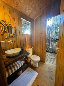 a wooden bathroom with a toilet and a sink at Arpoador Eco-Lodge in Tutóia