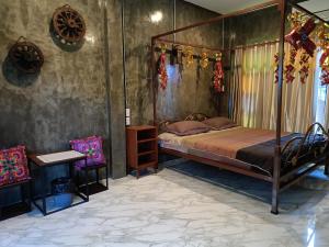 a bedroom with a canopy bed and a table and chairs at ต้นโพธิ์โฮมสเตย์ 