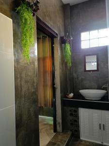 uma casa de banho com um lavatório, um espelho e um lavatório. em ต้นโพธิ์โฮมสเตย์ 