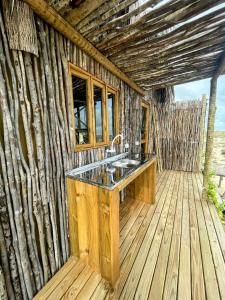 a bathroom with a sink on a wooden deck at Arpoador Eco-Lodge in Tutóia