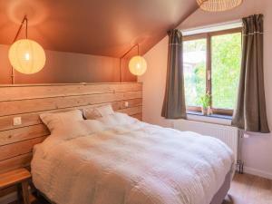um quarto com uma cama grande e uma janela em Cosy holiday home in Modave in a charming neighbourhood em Modave