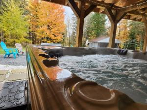 een hot tub in de achtertuin met een blauwe stoel bij Havre de détente avec foyer et spa in Sainte-Lucie-de-Doncaster