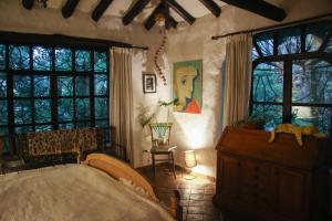 a bedroom with a bed and a dresser and windows at Espacio Pueblo. Galería rural in Amaguaña