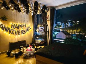 a bedroom with a happy anniversary sign on a window at Cloud River Homestay in Da Lat