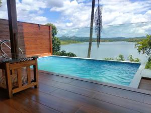 a swimming pool with a view of a body of water at LakeRose Wayanad Resort in Ambalavayal