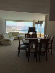 a living room with a table and chairs and a couch at SAN ALFONSO DEL MAR HERMOSA VISTA A LA BAHIA 4D/3B in Algarrobo