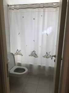 a bathroom with a toilet and a shower curtain at SAN ALFONSO DEL MAR HERMOSA VISTA A LA BAHIA 4D/3B in Algarrobo