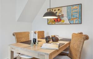 a wooden table with chairs and a painting on the wall at Nice Apartment In Snderborg With Kitchen in Sønderborg