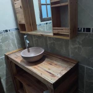 ein Badezimmer mit einem Spülbecken auf einer Holztheke in der Unterkunft Alquileres de la sierras gde in Tandil