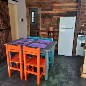 eine Küche mit einem Tisch und Stühlen sowie einem Kühlschrank in der Unterkunft Alquileres de la sierras gde in Tandil