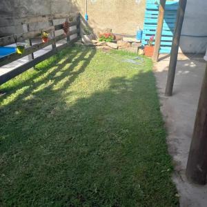 einen Hof mit einer Holzbank und Gras in der Unterkunft Alquileres de la sierras gde in Tandil