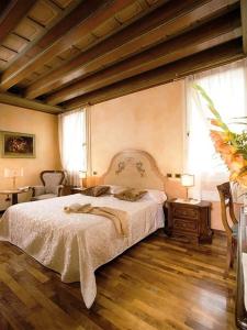 ein Schlafzimmer mit einem großen Bett und Holzboden in der Unterkunft Hotel Il Chiostro in Oppeano