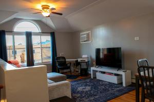 a living room with a couch and a tv and a window at BGI Rentals in Brooklyn