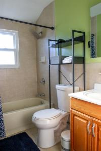 布魯克林的住宿－BGI Rentals，浴室配有卫生间、浴缸和水槽。