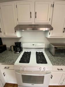 a white stove top oven in a kitchen at Boston 2bd- Walk to Harvard, MIT, subway Parking in Somerville