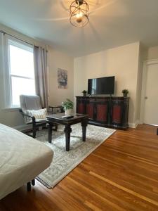 a living room with a tv and a coffee table at Boston 2bd- Walk to Harvard, MIT, subway Parking in Somerville