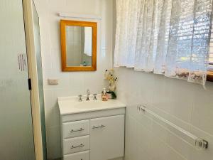 a white bathroom with a sink and a mirror at Wallaroo Sunset home in Wallaroo