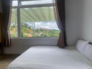 Postel nebo postele na pokoji v ubytování Lacami Dalat Hotel