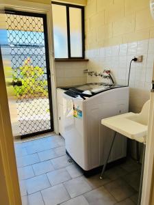 a small kitchen with a sink and a washing machine at Wallaroo Sunset home in Wallaroo