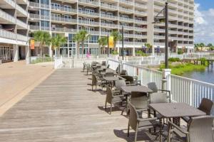 a boardwalk with tables and chairs in front of a building at Laketown Wharf 1233 luxury condo in Panama City Beach