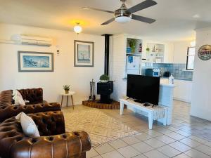 uma sala de estar com 2 sofás e uma televisão de ecrã plano em Wallaroo Sunset home em Wallaroo