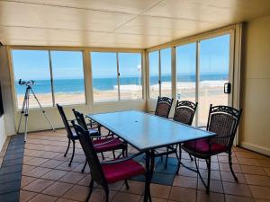ein Esszimmer mit einem Tisch und Stühlen sowie Strand in der Unterkunft Wallaroo Sunset home in Wallaroo
