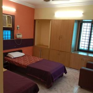 a bedroom with two beds and a cabinet and a window at WISHTREE DORMITORY/CORPORATE DORMITORY FOR TECHIES AND TRAINEES in Chennai