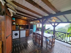 a kitchen with a table on a wooden deck at Lodge grenadine in Deshaies