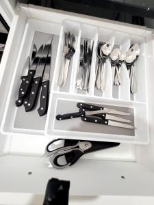 biała szuflada z widelcami, nożami i przyborami kuchennymi w obiekcie Comfort oasis family getaway w mieście Henley Brook