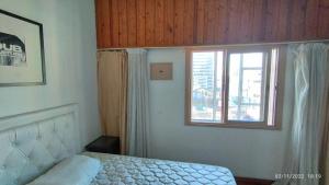 Schlafzimmer mit einem Bett und einem Fenster in der Unterkunft Apart Corrientes Broadway in Buenos Aires