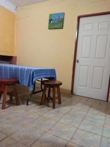 Zimmer mit einem Tisch, 2 Bänken und einer Tür in der Unterkunft Don Chacon Fest in Volcán