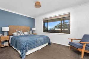 une chambre avec un lit, une chaise et une fenêtre dans l'établissement Sandals at the Bay Upstairs sleeps 6 Hyams Beach, à Hyams Beach