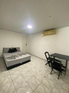 Schlafzimmer mit einem Bett, einem Tisch und einem Schreibtisch in der Unterkunft Conexão 021 in Boa Vista