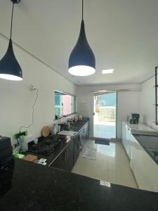a kitchen with two pendant lights and a counter top at Conexão 021 in Boa Vista