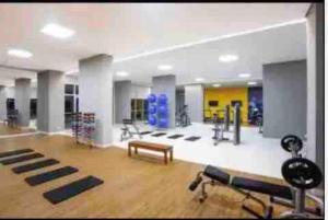 a gym with exercise equipment in a large room at APT Perfeito, duas suítes no shopping Dfplaza in Brasilia